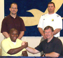 Alumnus Mike Olson and Sean Dahley are pictured with football coaches Jamie Cruce and Everest Martin.